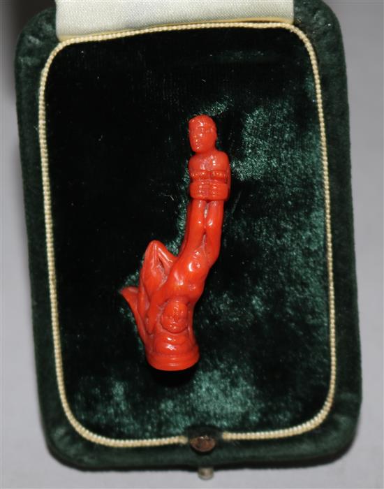 A coral figurative brooch with seal